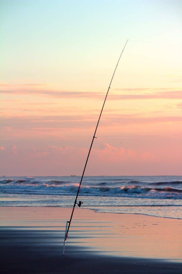 A peaceful beach scene with fishing rod at sunset in Guaratuba, Brazil. Tranquil and picturesque setting.