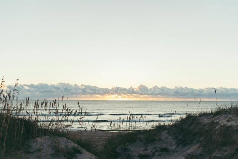 Serene sunset over sands and sea at Avon Beach, NC, tranquil and picturesque.