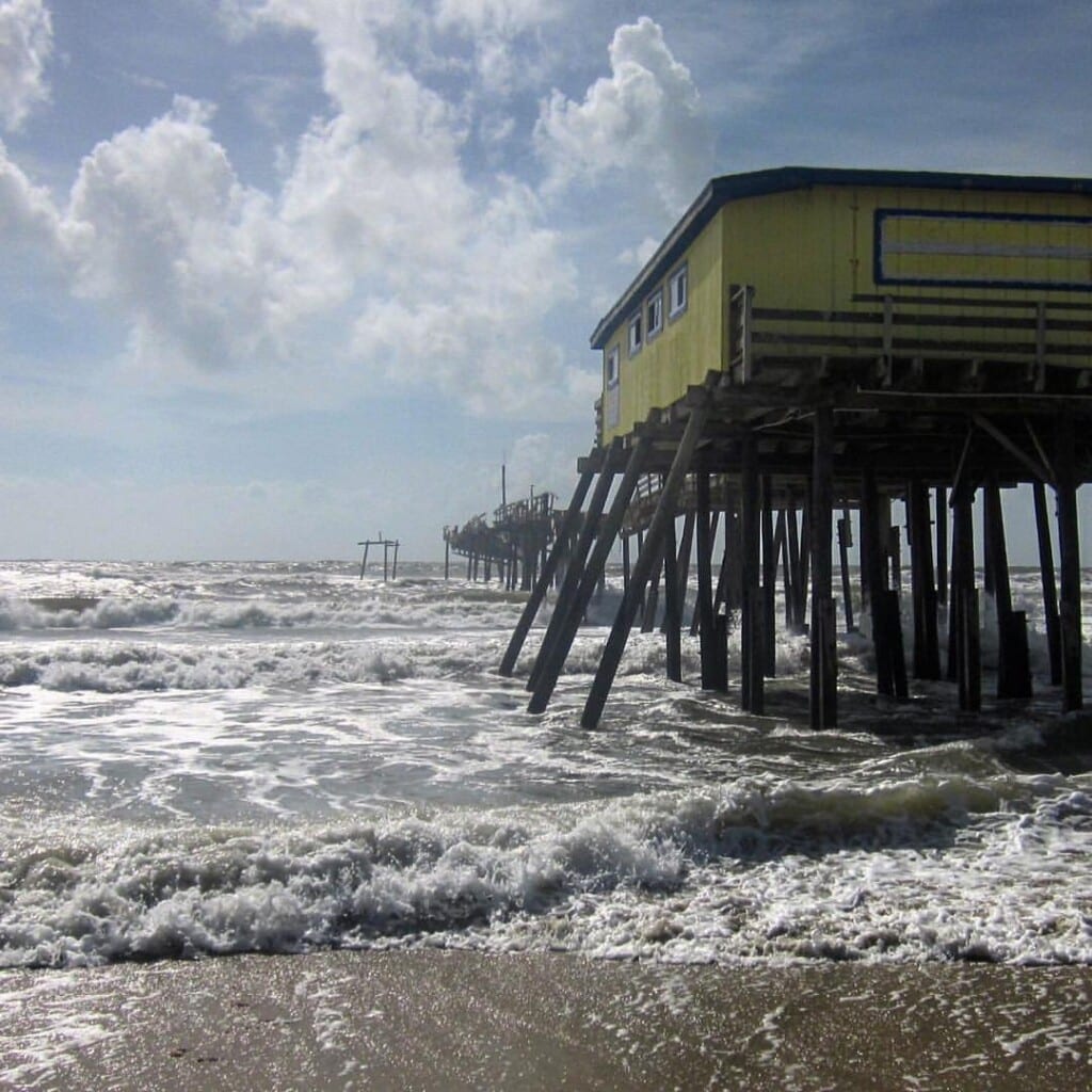 The old Frisco Pier pilings standing in the surf close to high tide on Hatteras Island