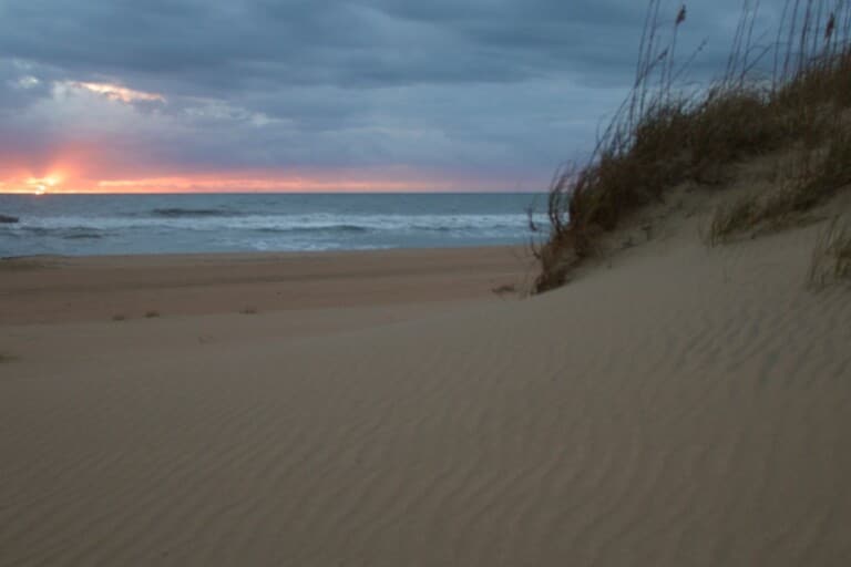 Autumn sunrise over the ocean behind a sand dune at Cape Hatteras National Seashore