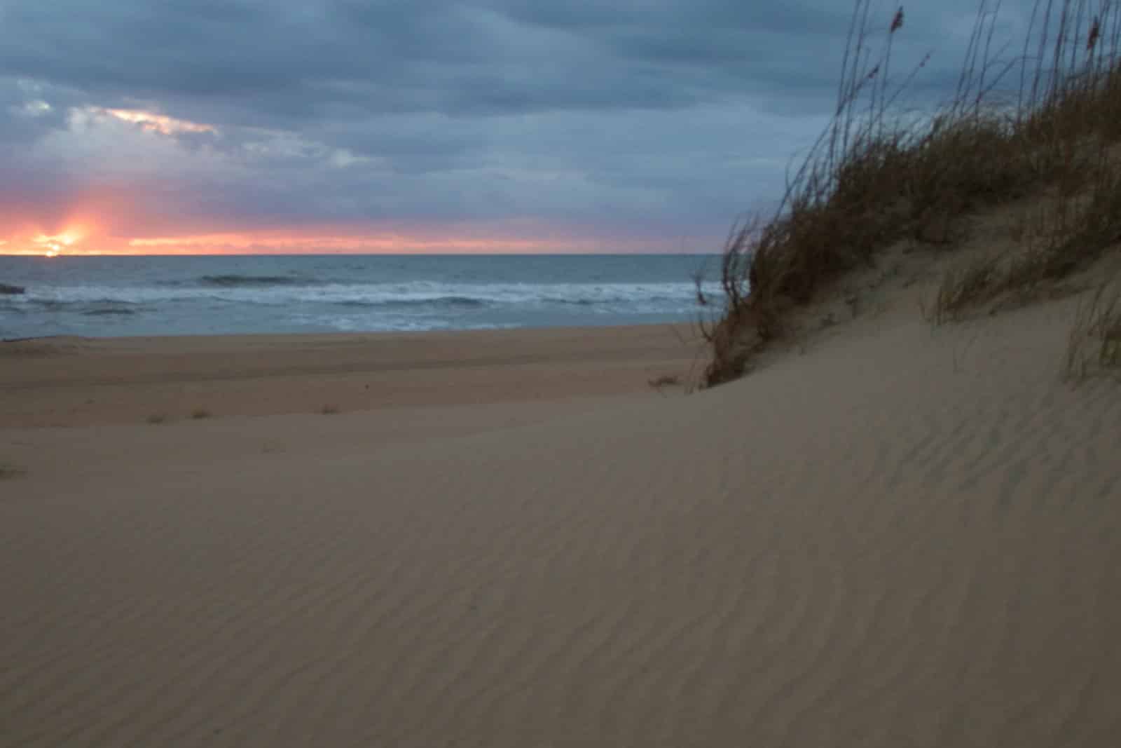 Autumn sunrise over the ocean behind a sand dune at Cape Hatteras National Seashore