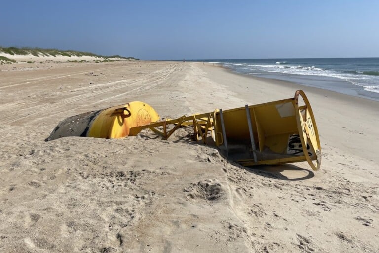 A washed-up Coast Guard channel buoy lying on the open beach north of ORV Ramp 34 near Avon on Hatteras Island