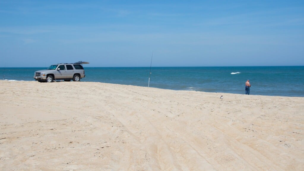 Surf anglers fishing beside a pickup truck parked on the beach near Ramp 38 in Avon, Hatteras Island