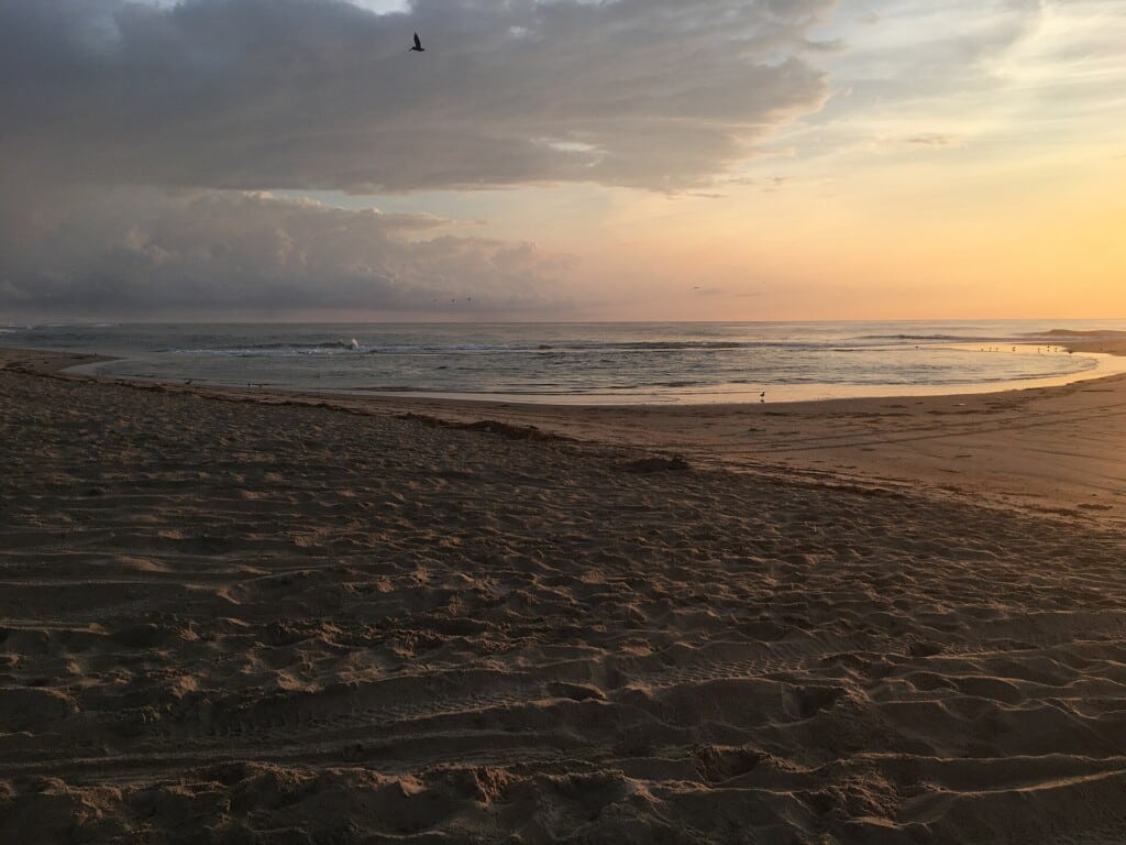 Sunrise at Cape Point at high tide in August with the sun low over the water
