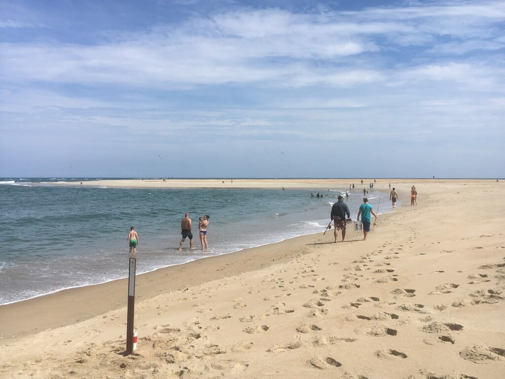 Summer visitors walking the beach at Cape Point under a blue sky