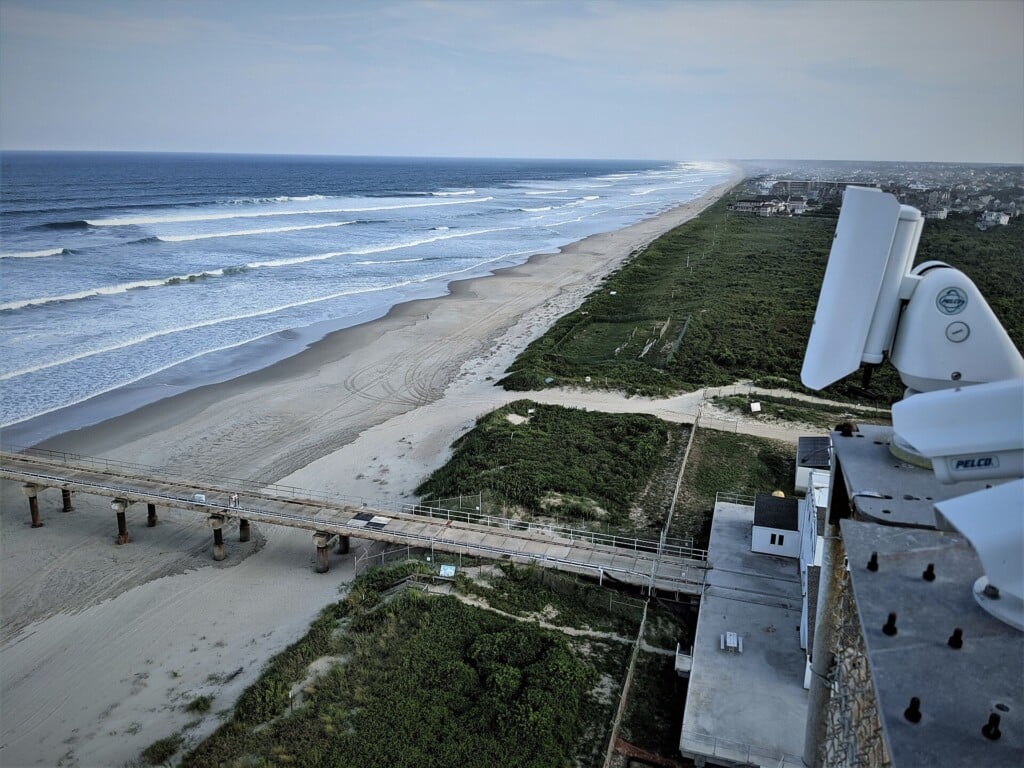 A coast camera mounted on a tower in the dune above the beach at the Duck research pier