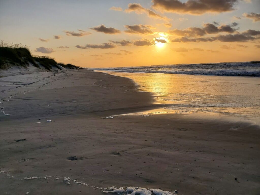 Sunrise over long swell lines east of the Frisco beach access after Hurricane Teddy