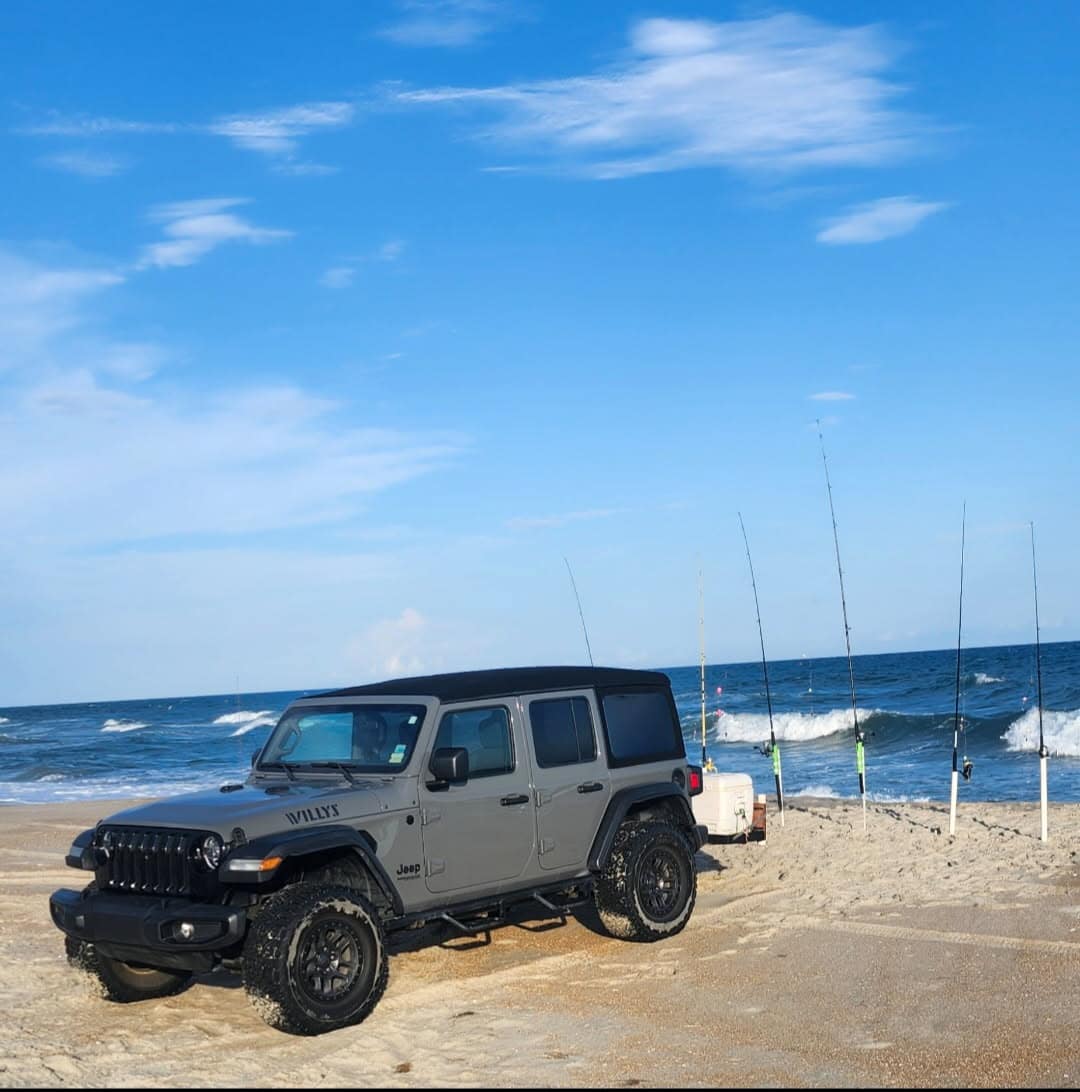 A Jeep Wrangler Willys on the sand with five surf rods in the spikes, Outer Banks